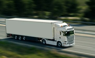 A truck driving fast on a road