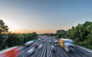Sunset view heavy traffic moving at speed on UK motorway in England.